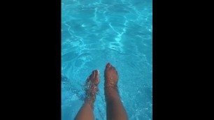 Ebony splashes her feet in the pool.